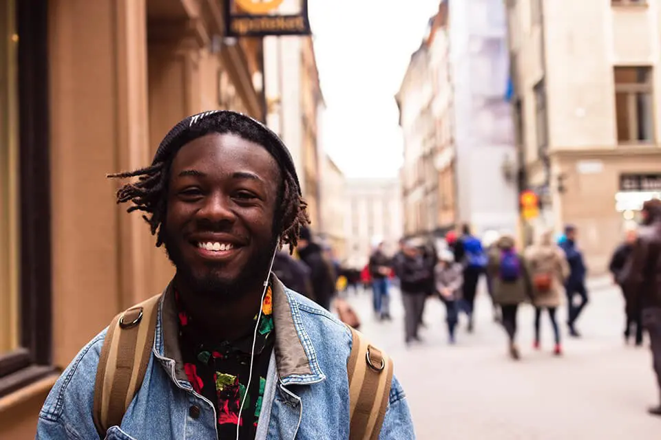 Man smiling as he walks down the street showing he is mentally strong