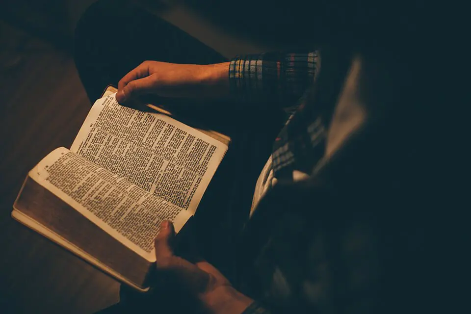 Man reading a book by dim light