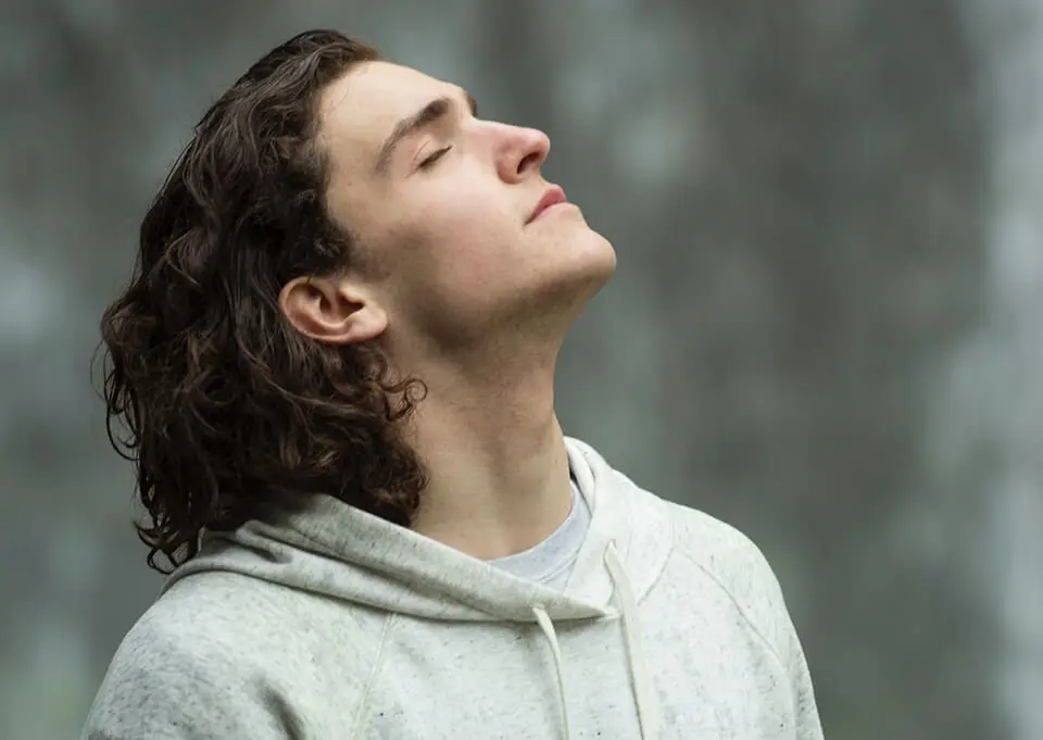 Man with head tilted back, taking a deep breath