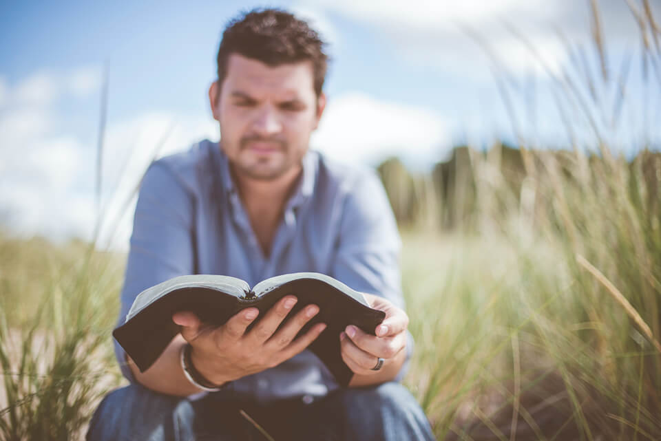 Man sitting outside, reading his gratitude journal