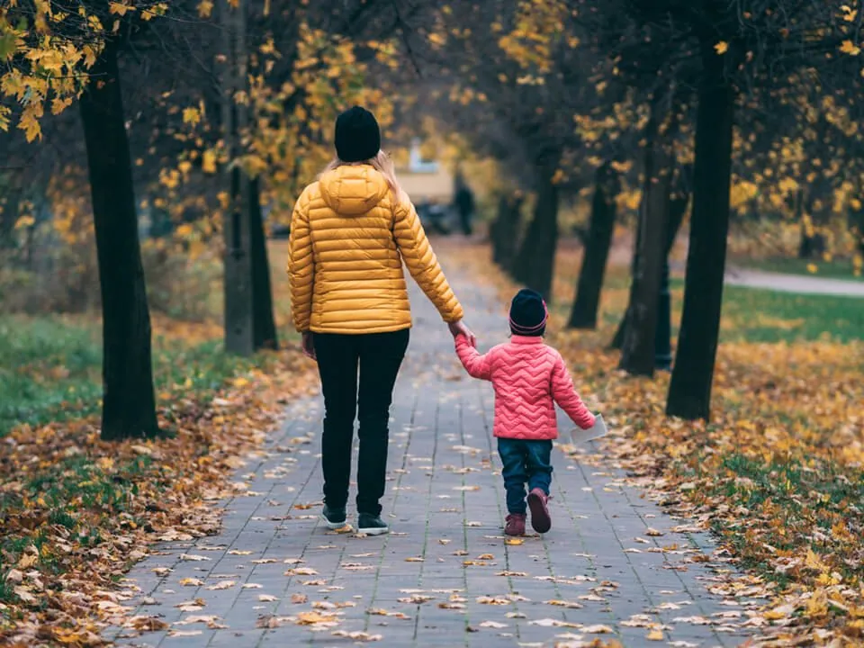 Woman walking outside with her daughter.