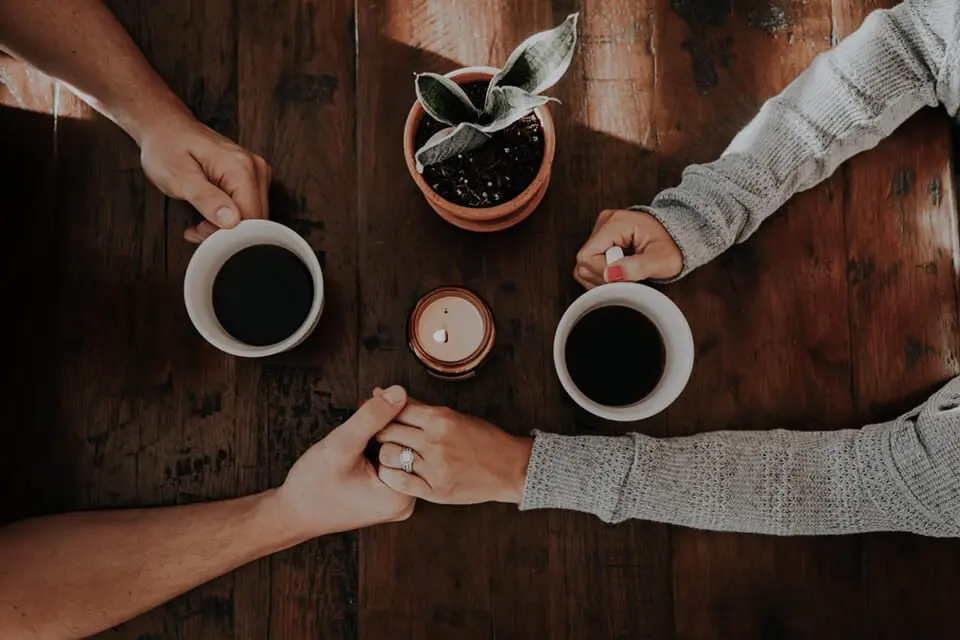 Two friends engaged in deep conversation while drinking coffee