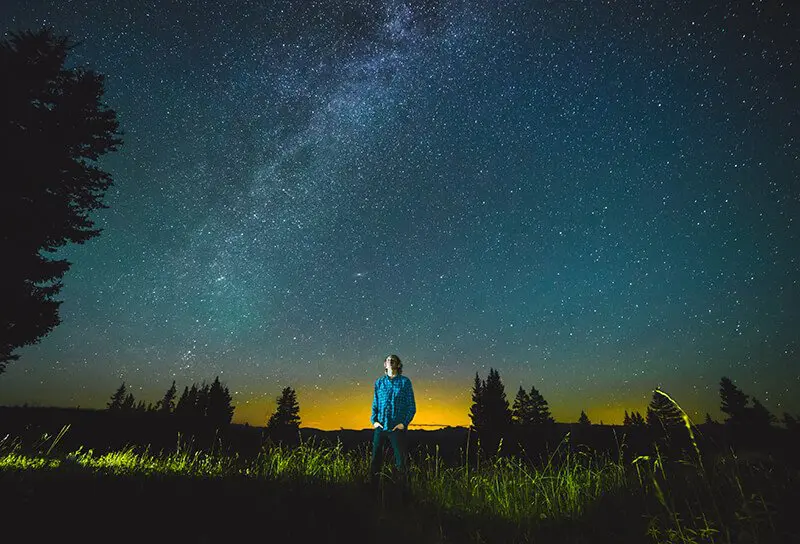 Man lost in thought in scenic night landscape