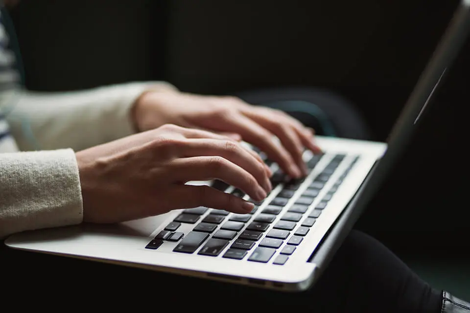 Closeup of woman typing on her laptop