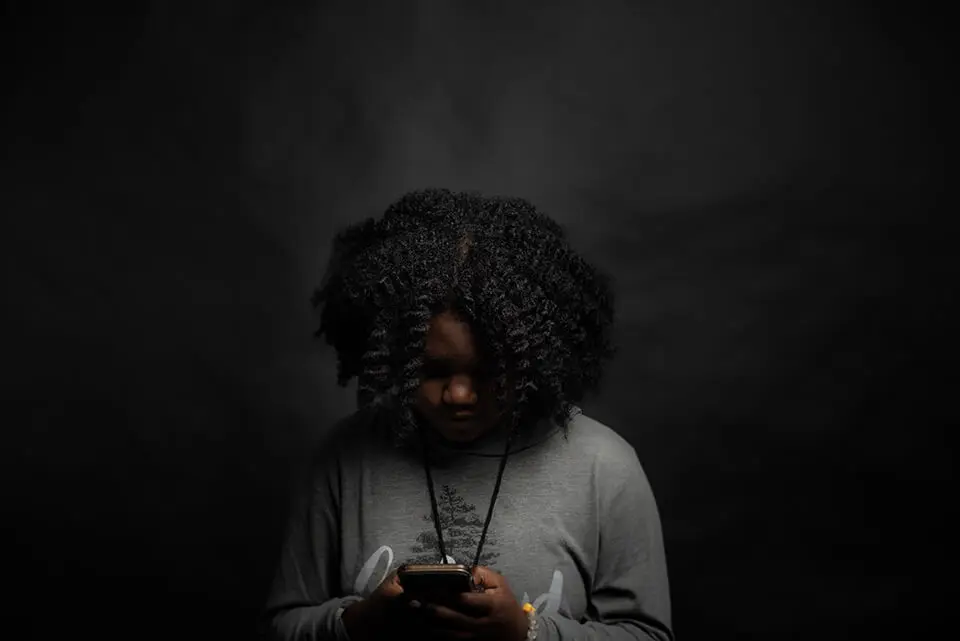 Woman looking down, reading news on phone