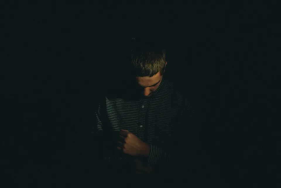 Man in the dark with his head down