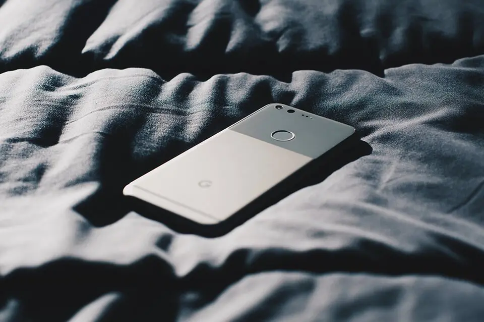 Phone turned down on top of bed