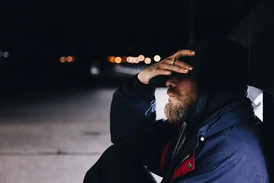 Man sitting with hands on head, frustrated