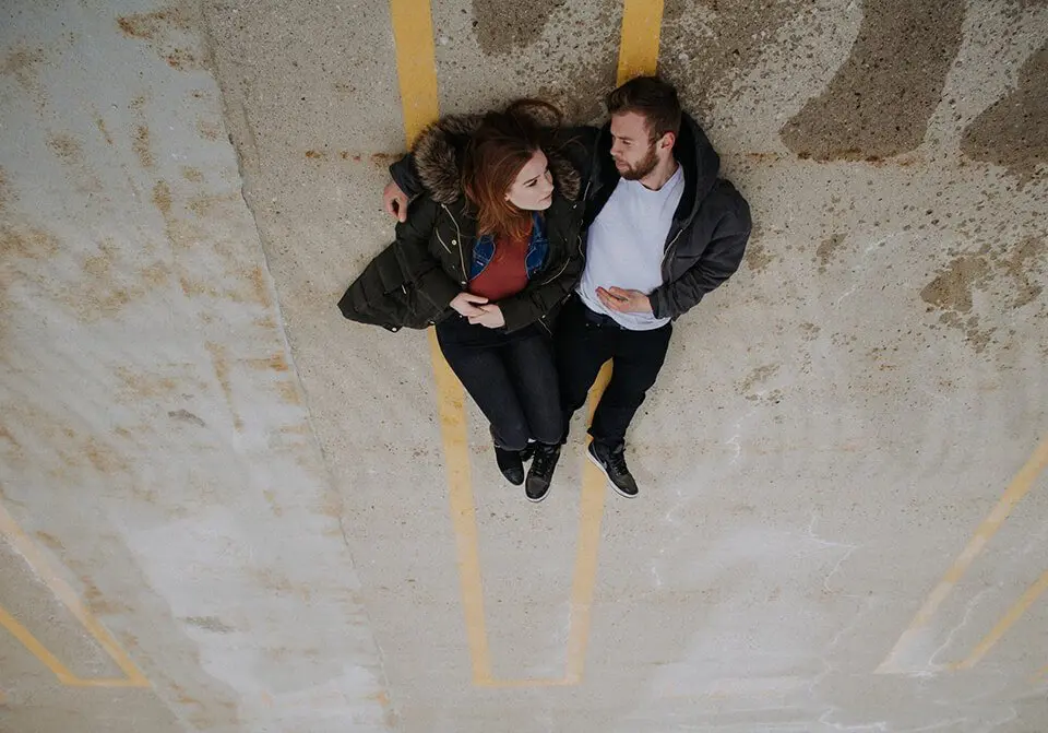Couple laying in parking lot having a conversation