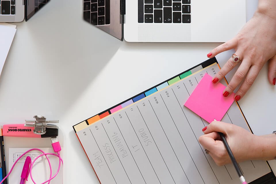Woman writing in calendar, prioritizing her tasks