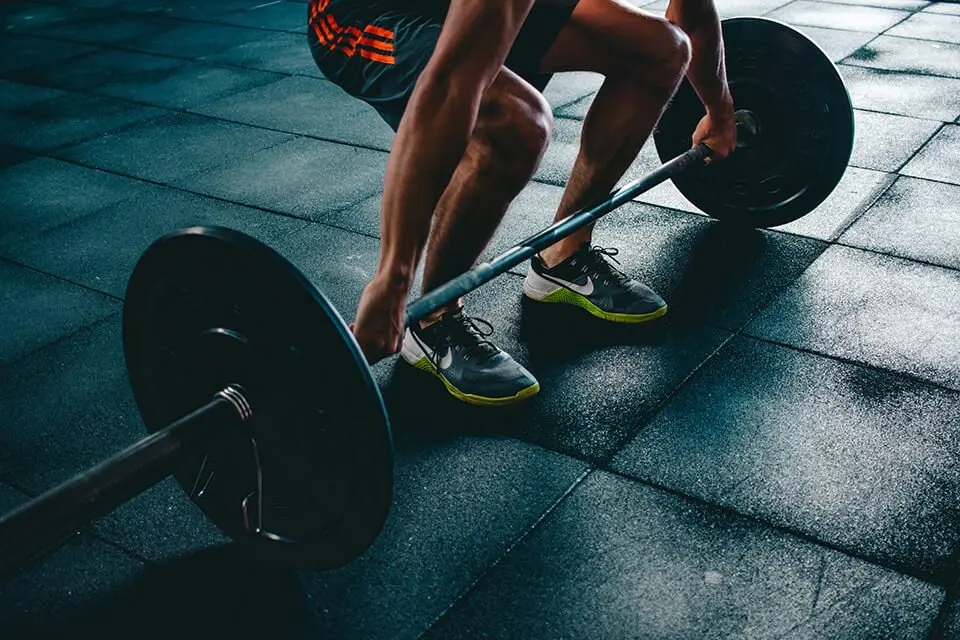 Man lifting a barbell with weights in the gym