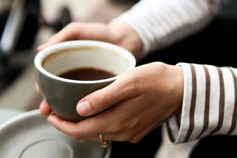 Hands cradling a warm mug of coffee