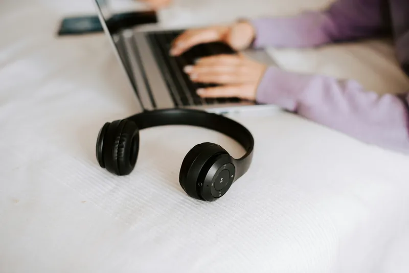 A pair of over-ear headphones resting on a closed laptop