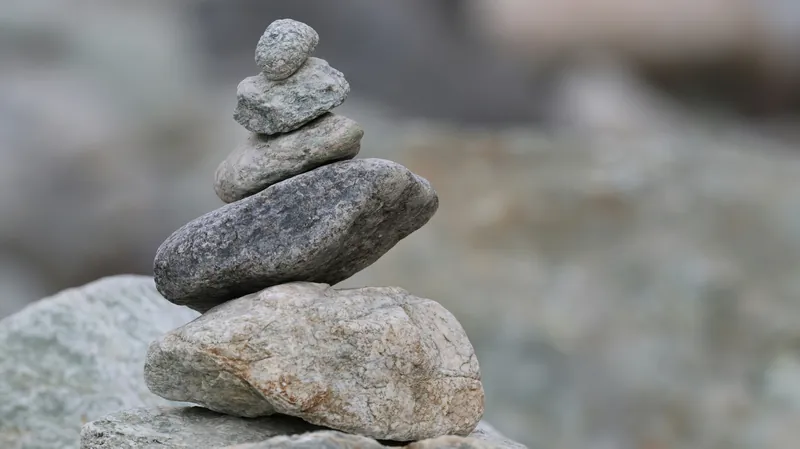 A stack of smooth balanced stones against a blurred natural background.