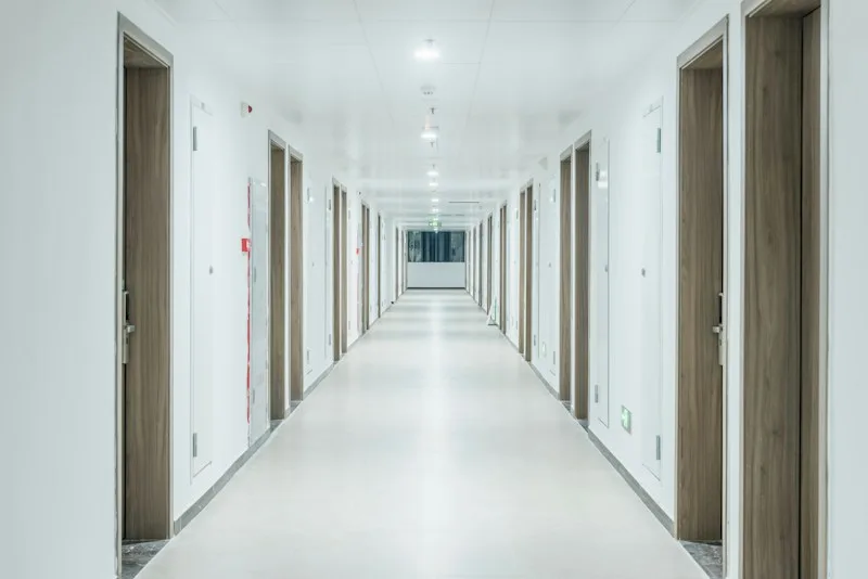 A long hallway lined with many identical closed doors, suggesting too many options and no clear choice