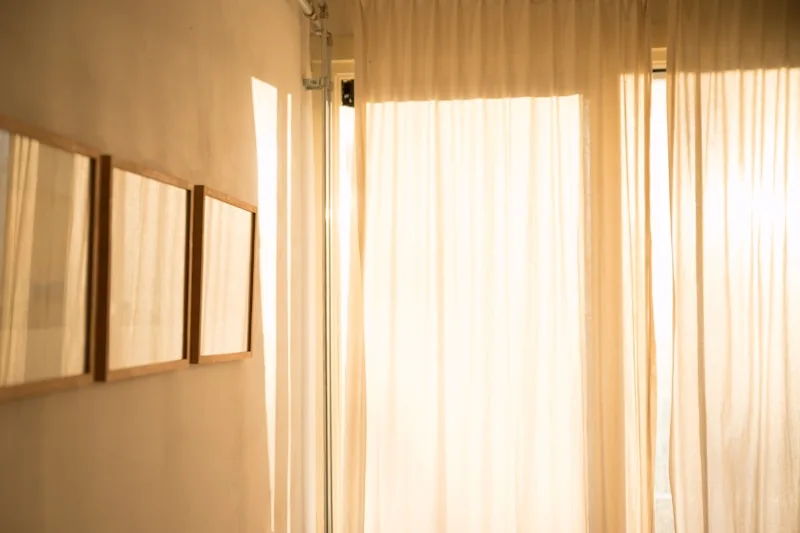 Soft daylight filtering through sheer white curtains in a quiet room.