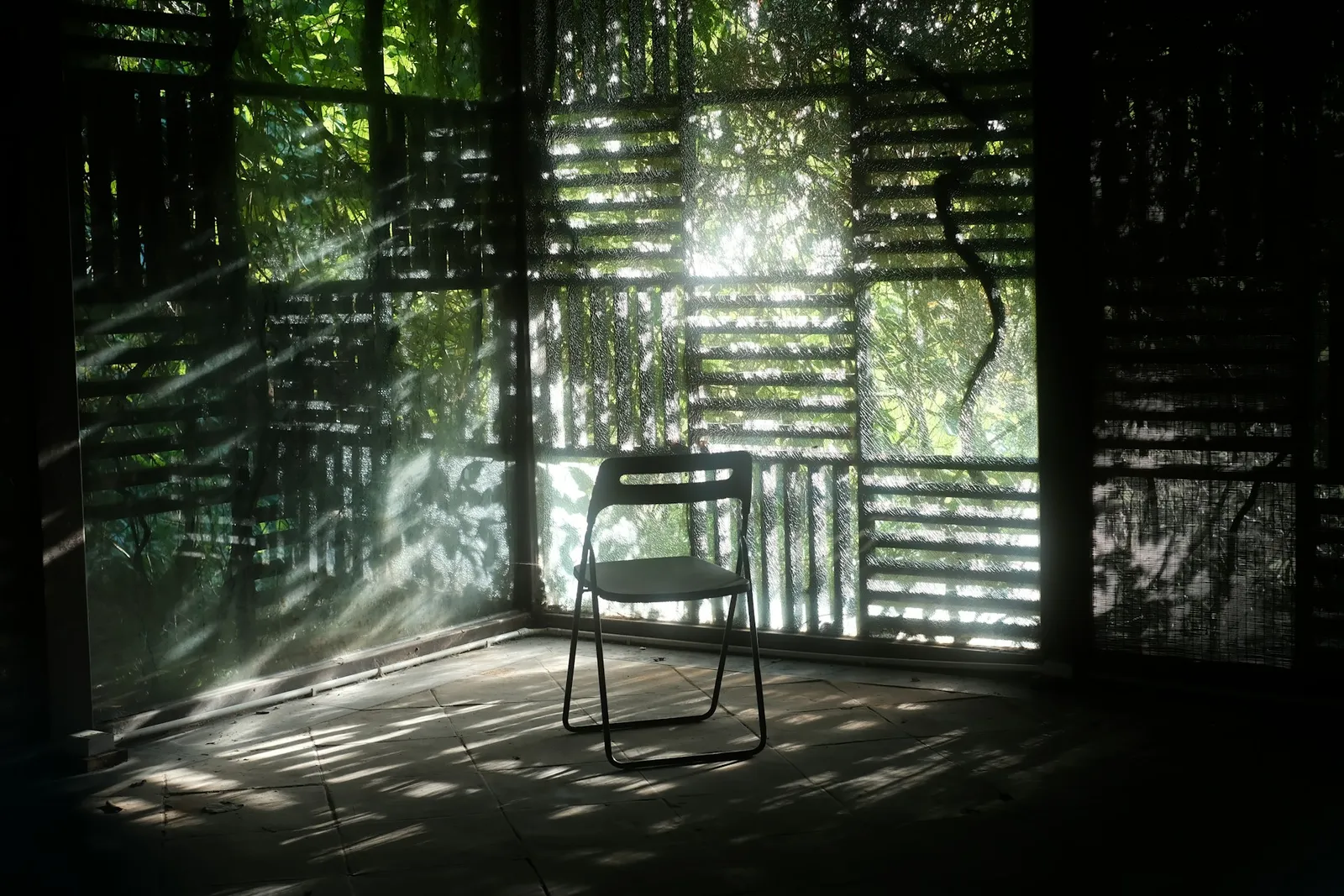 A single empty chair in a quiet room, with soft daylight filtering through the walls.