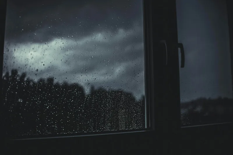 A single window on a grey morning, rain on the glass