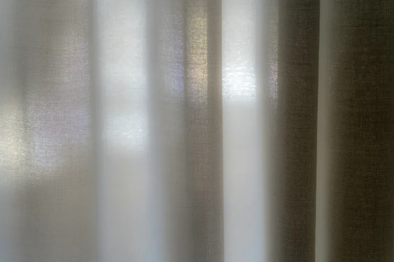 Soft morning light filtering through a sheer white curtain