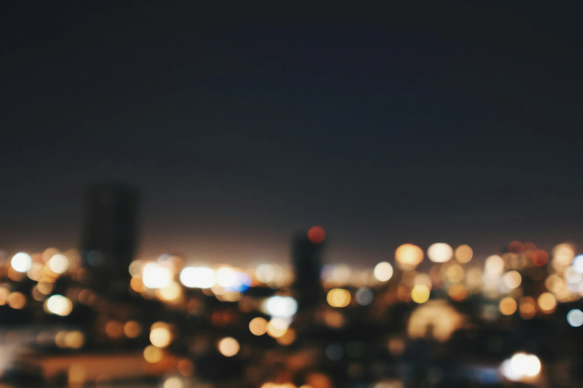 Blurred city lights at dusk, out of focus, suggesting scattered attention