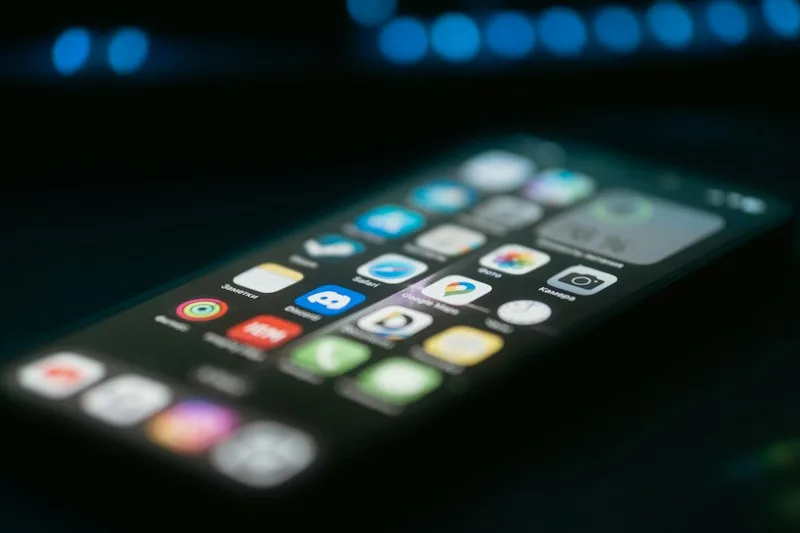 A phone screen glowing on a dark table at night