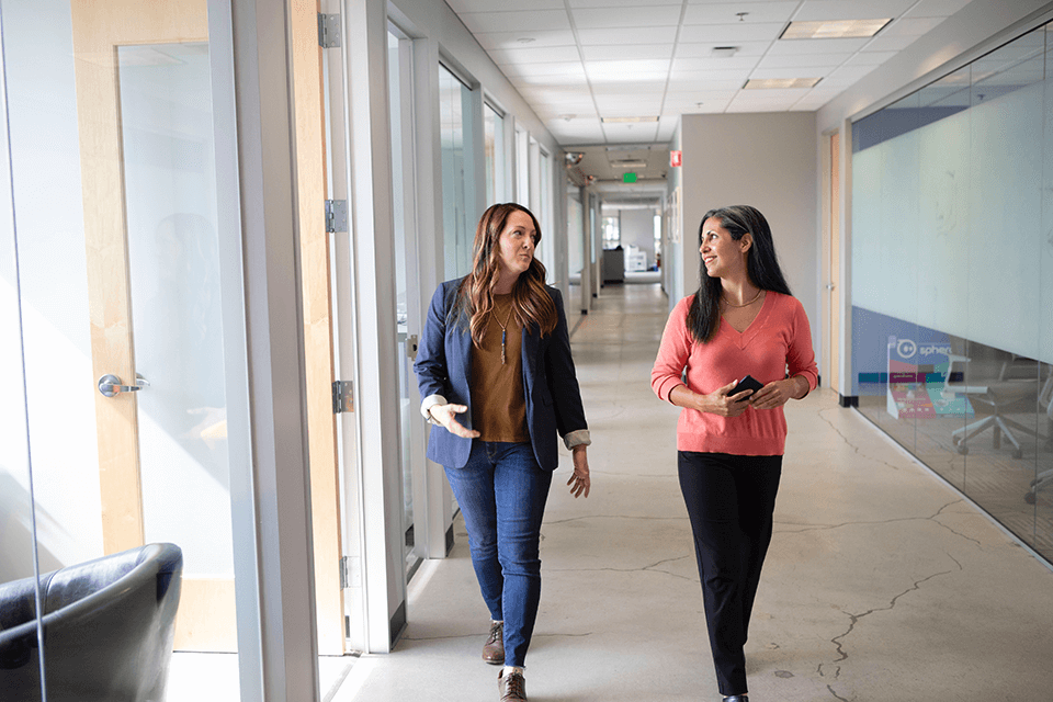 Two women having a walking meeting in an office
