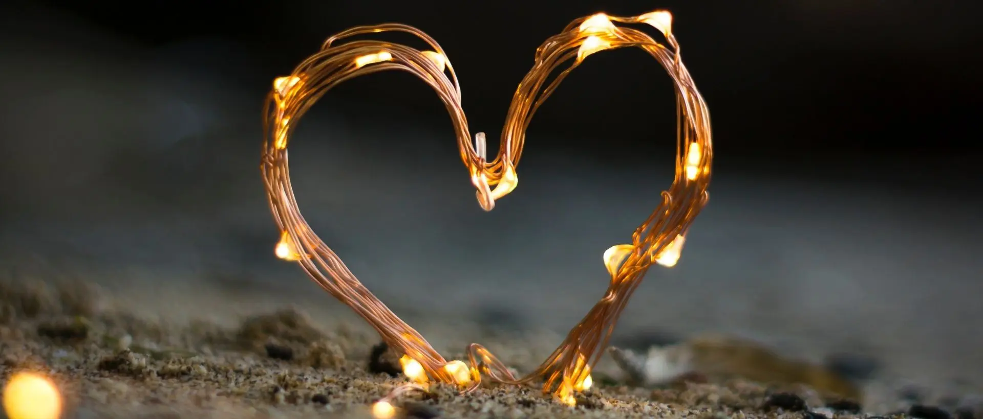 a heart made out of lights sitting on top of a rock.