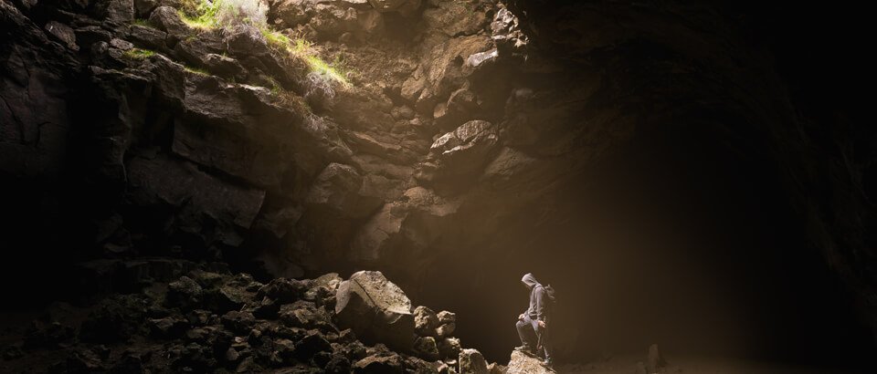 a man standing in the middle of a cave.