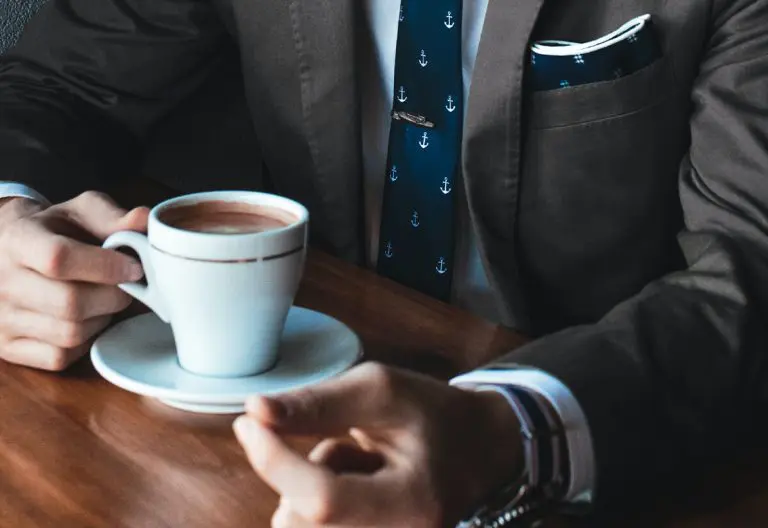 a man in a suit holding a cup of coffee.