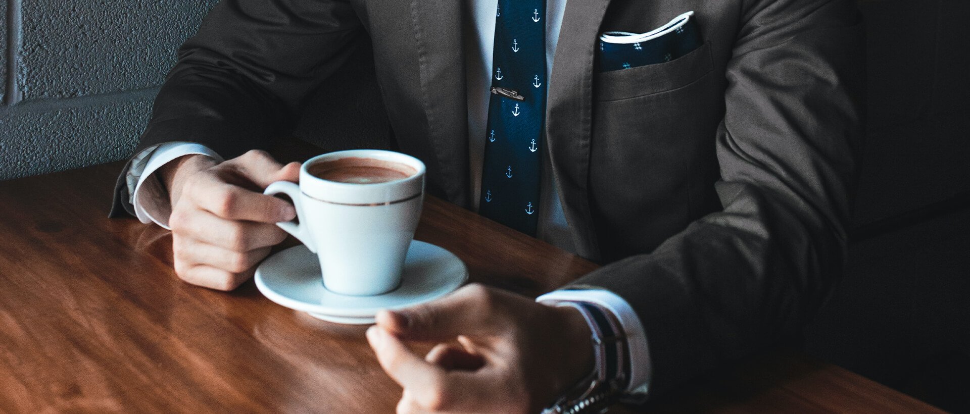 a man in a suit holding a cup of coffee.