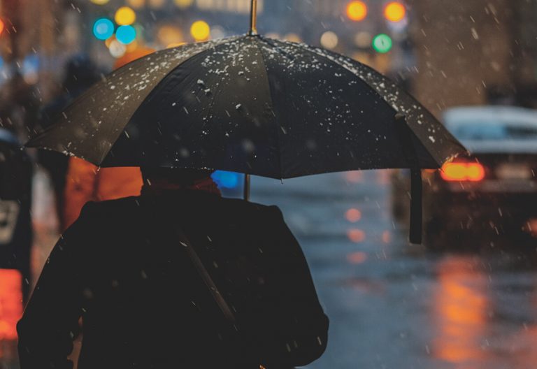 a person walking in the rain with an umbrella.
