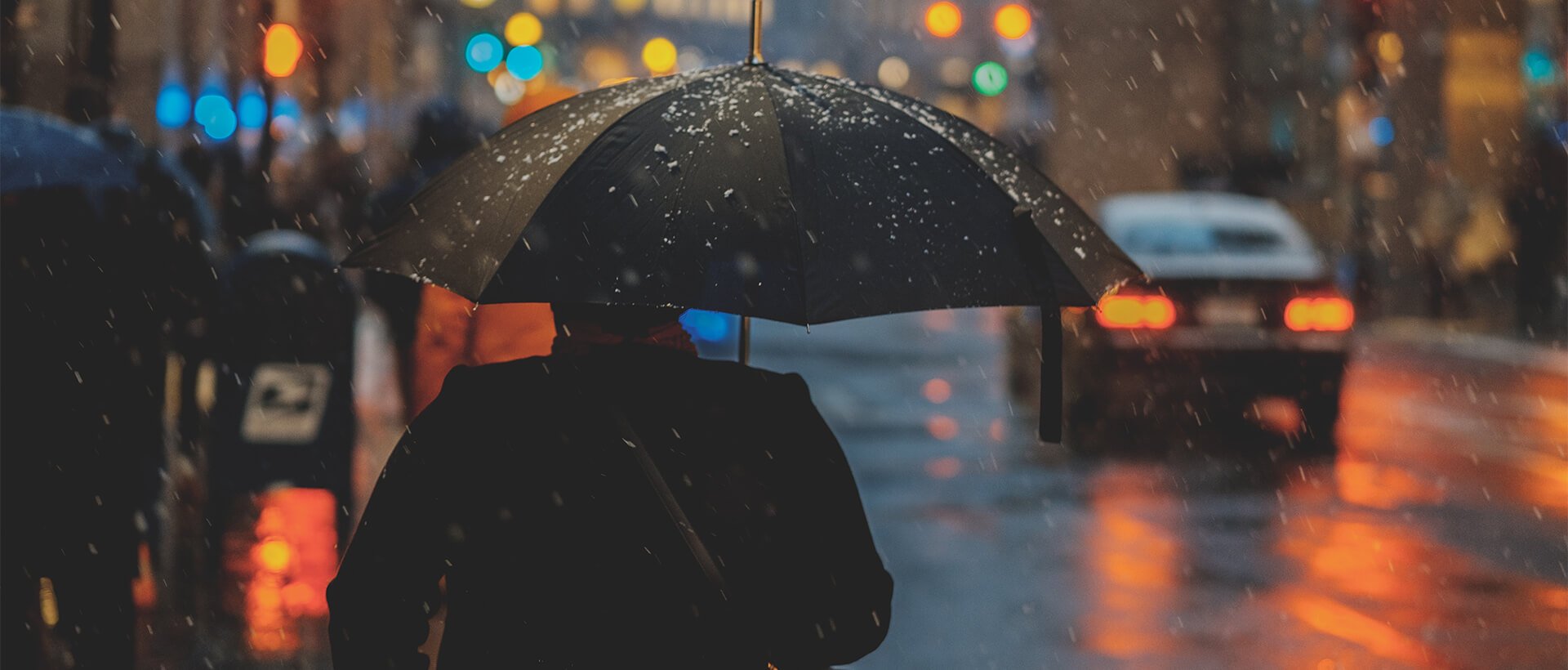 a person walking in the rain with an umbrella.