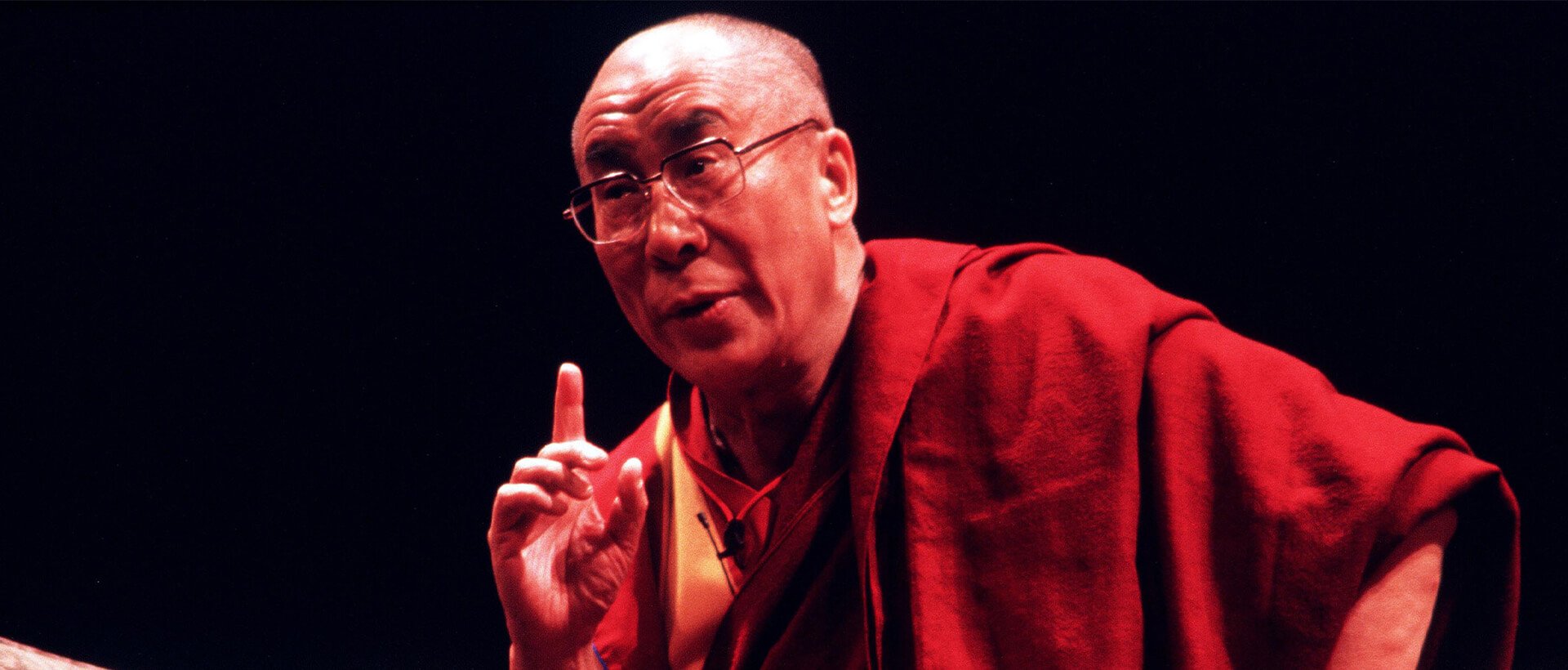 a man in a red robe is pointing at something.