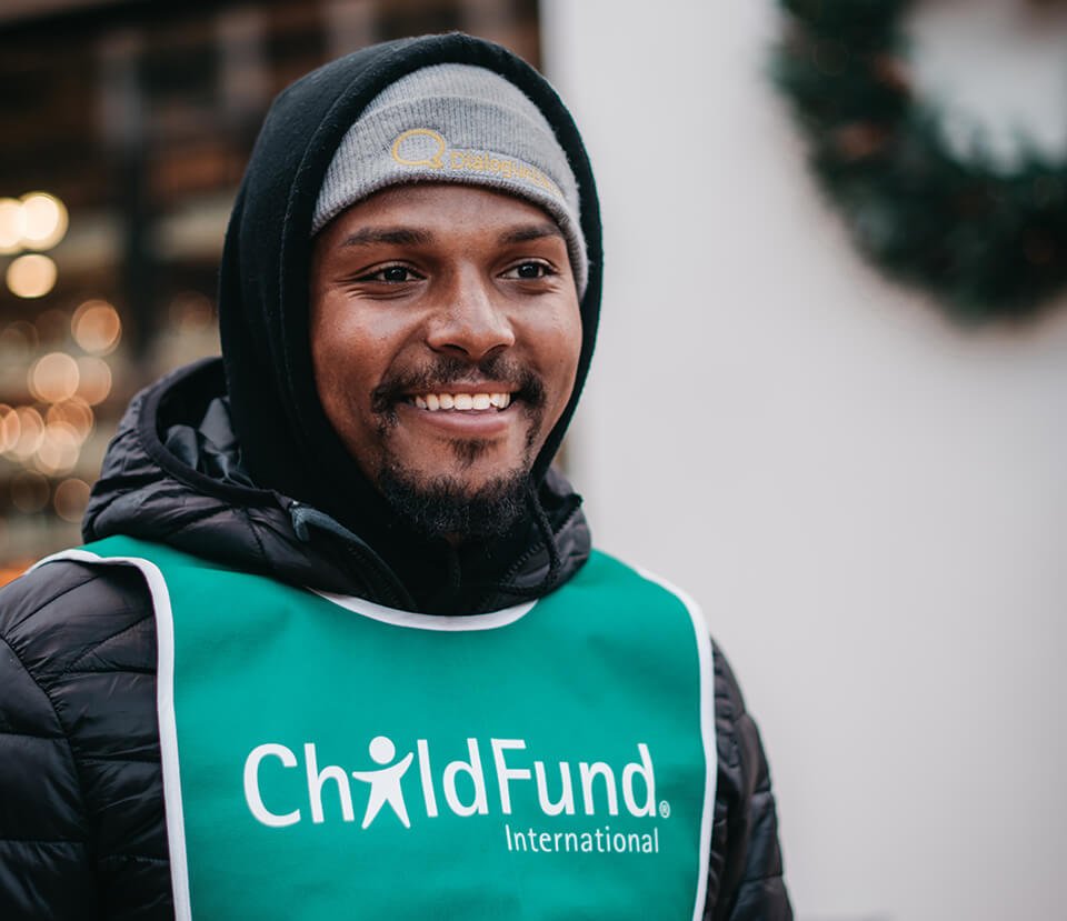 Man wearing a "ChildFund" vest, volunteering his time