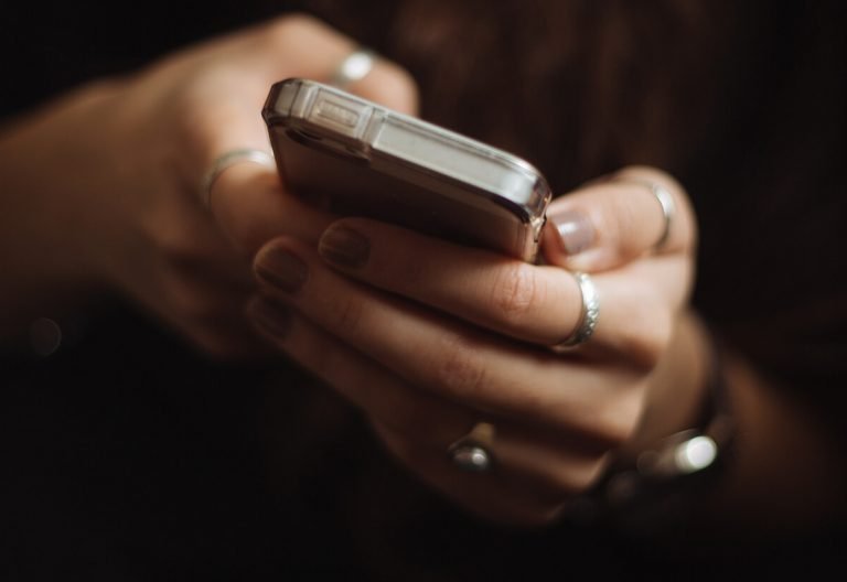 a close up of a person holding a cell phone.