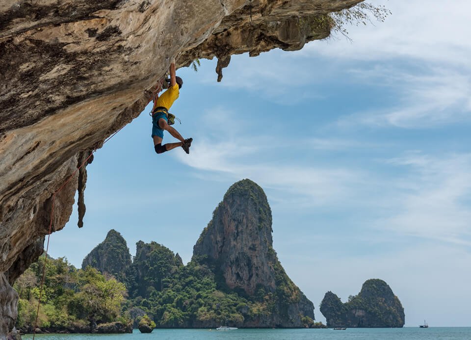 Man rock climbing up a steep cliff