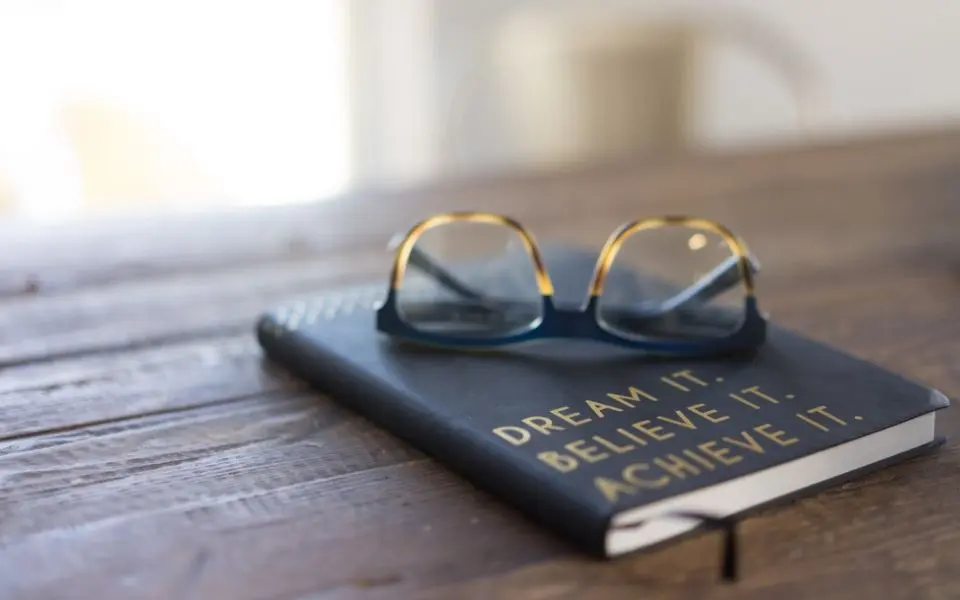 Journal with a pair of glasses resting on top of book