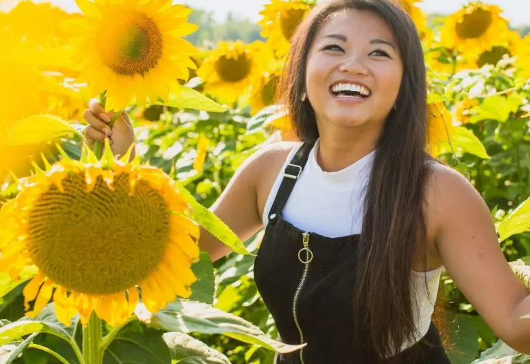 a woman standing in a field of sunflowers.