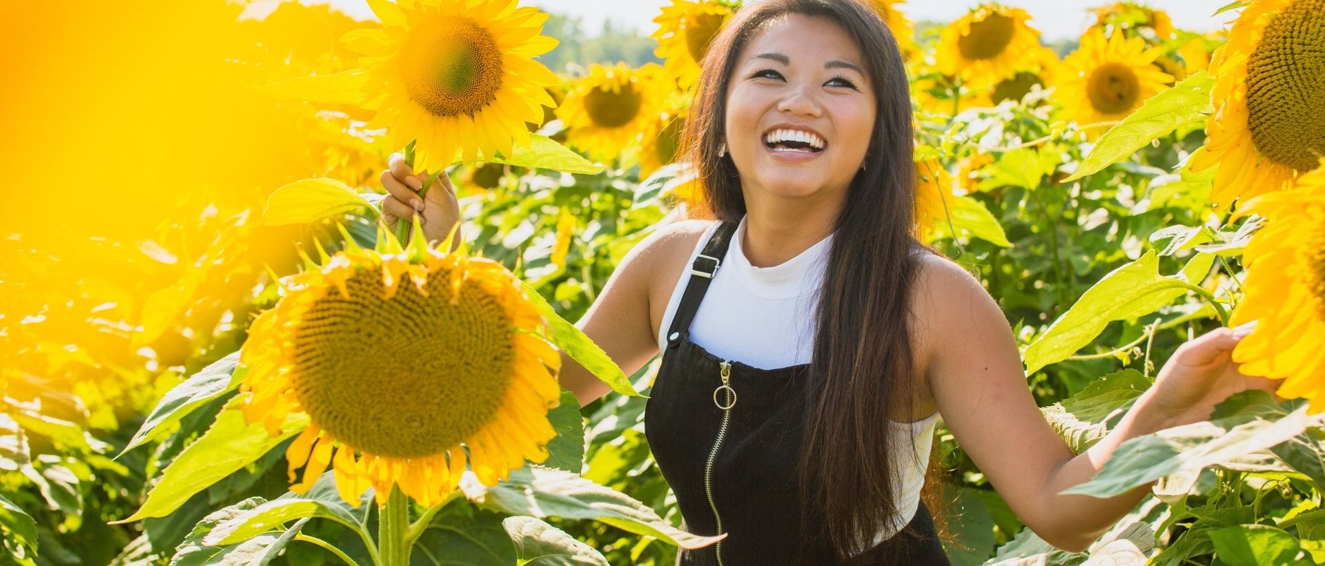a woman standing in a field of sunflowers.