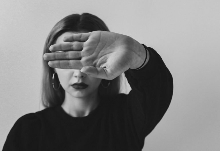 a woman covering her eyes with her hands.
