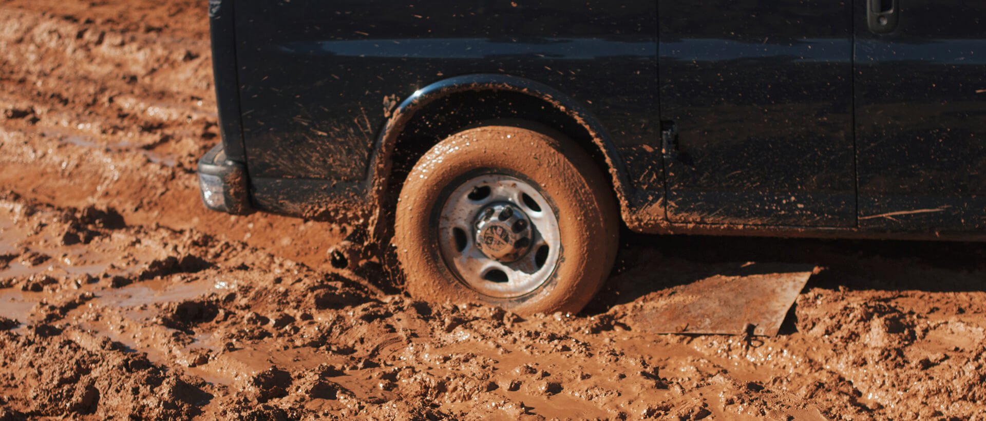 a close up of a truck tire on a dirt road.