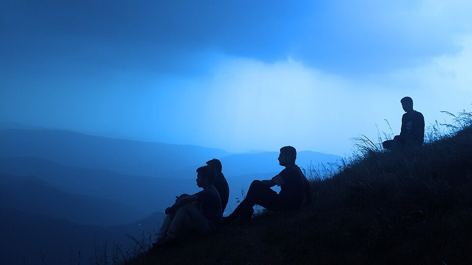 Group of friends in meditation on a hill
