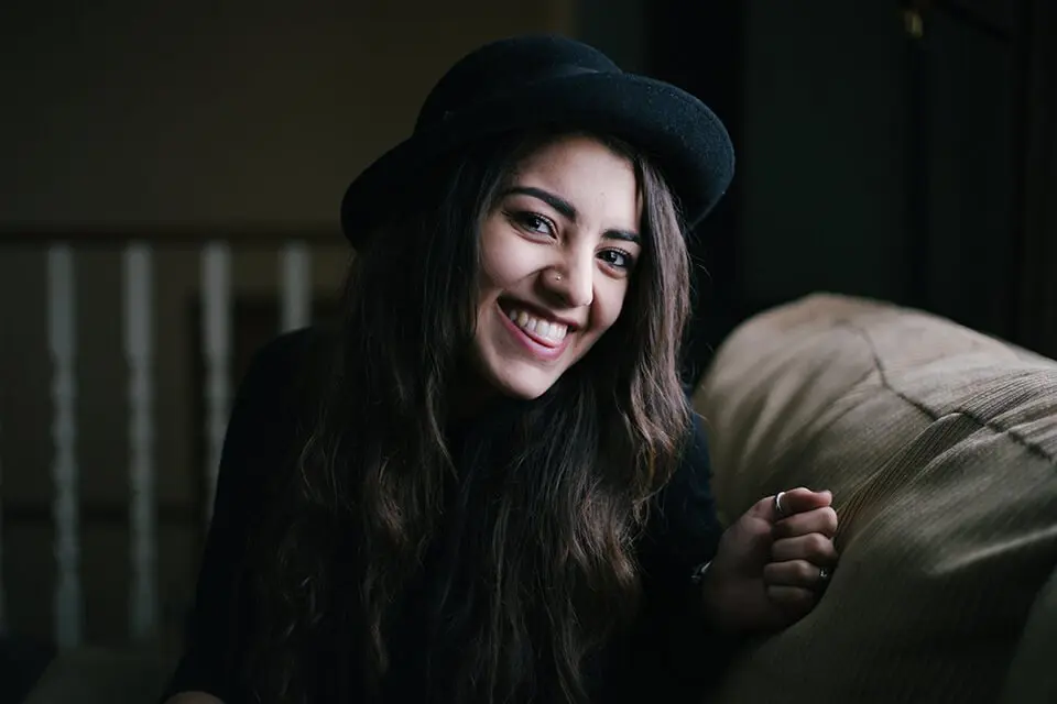 Woman wearing a hat cheekily smiling