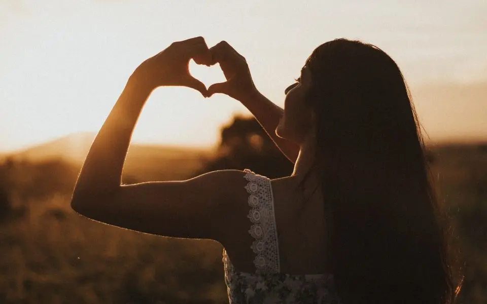 Woman holding up hands making a heart shape