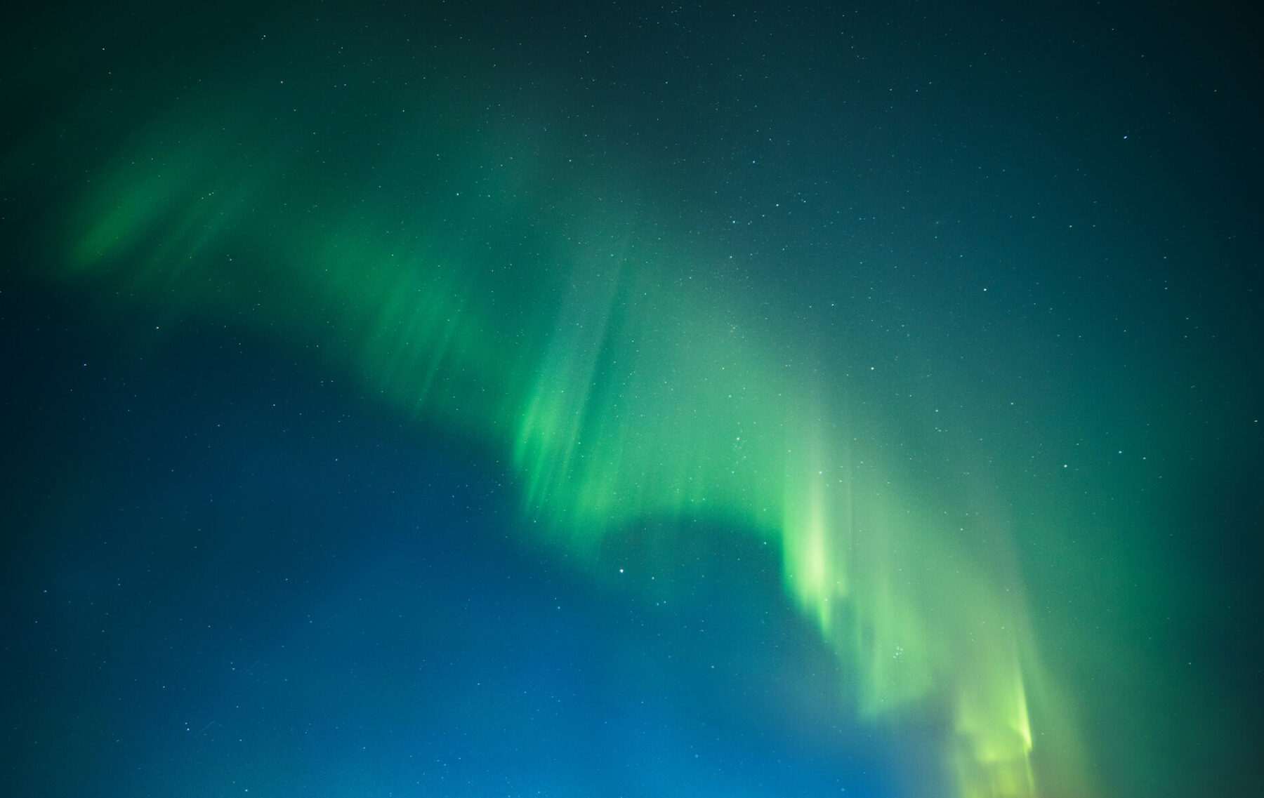 a bright green and blue aurora bore in the sky.