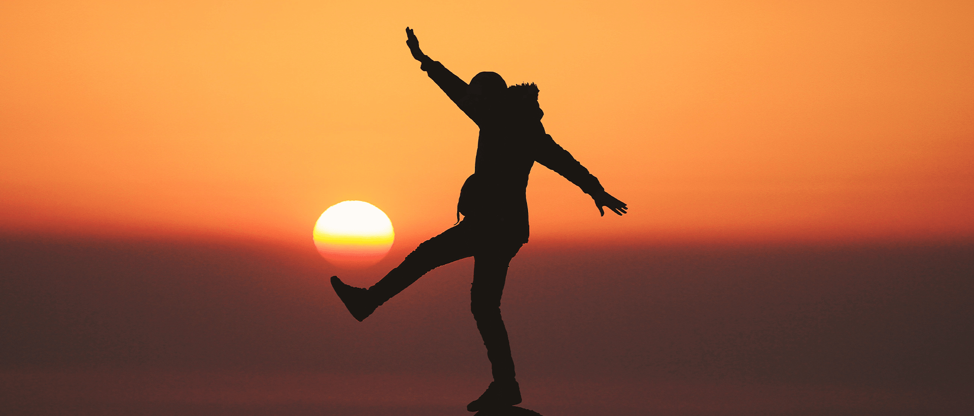 a person jumping in the air at sunset.