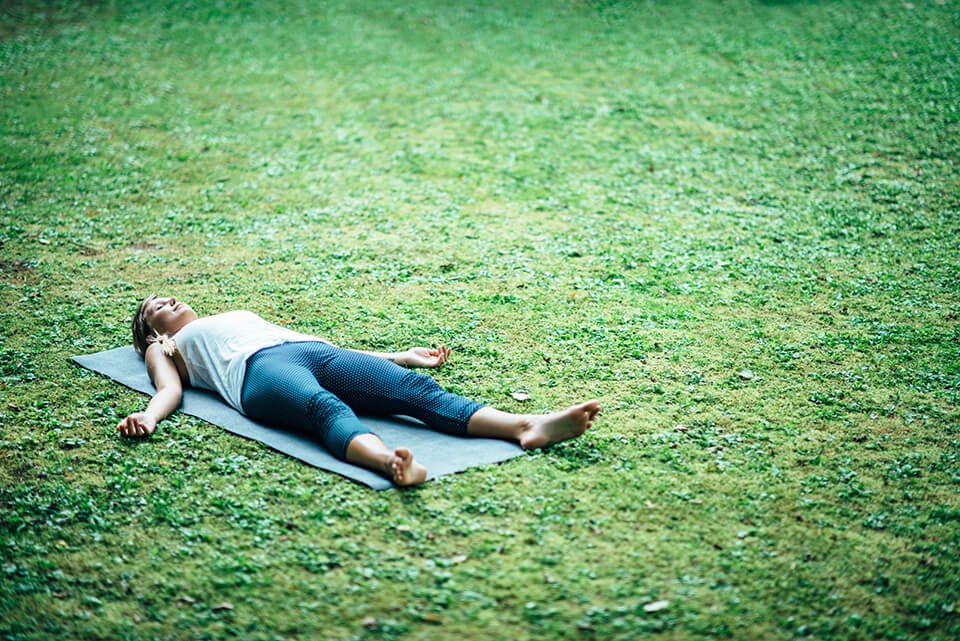 Woman lying down outside in meditation