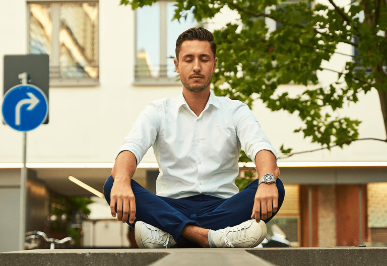 a man in white shirt and blue pants doing yoga.