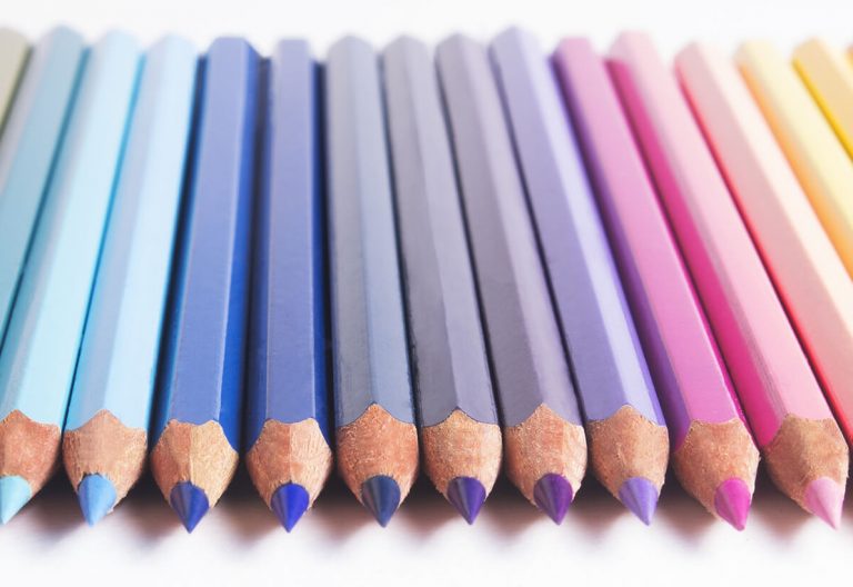 a group of colored pencils lined up in a row.
