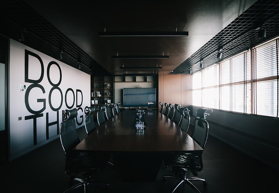 An empty conference room with the words "Do Good Things" written on the wall